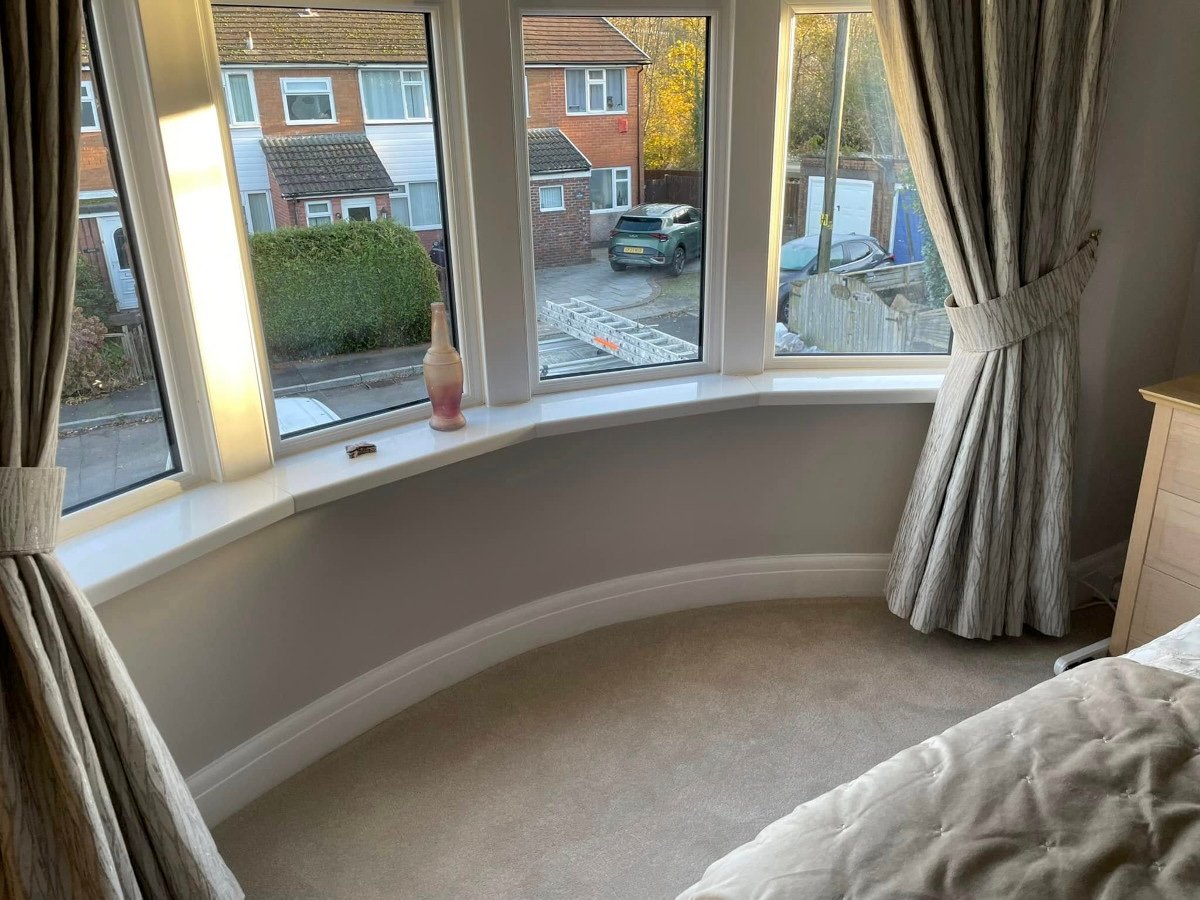 Bedroom with grey painted walls and bay window in Newport home by Orchid Decor
