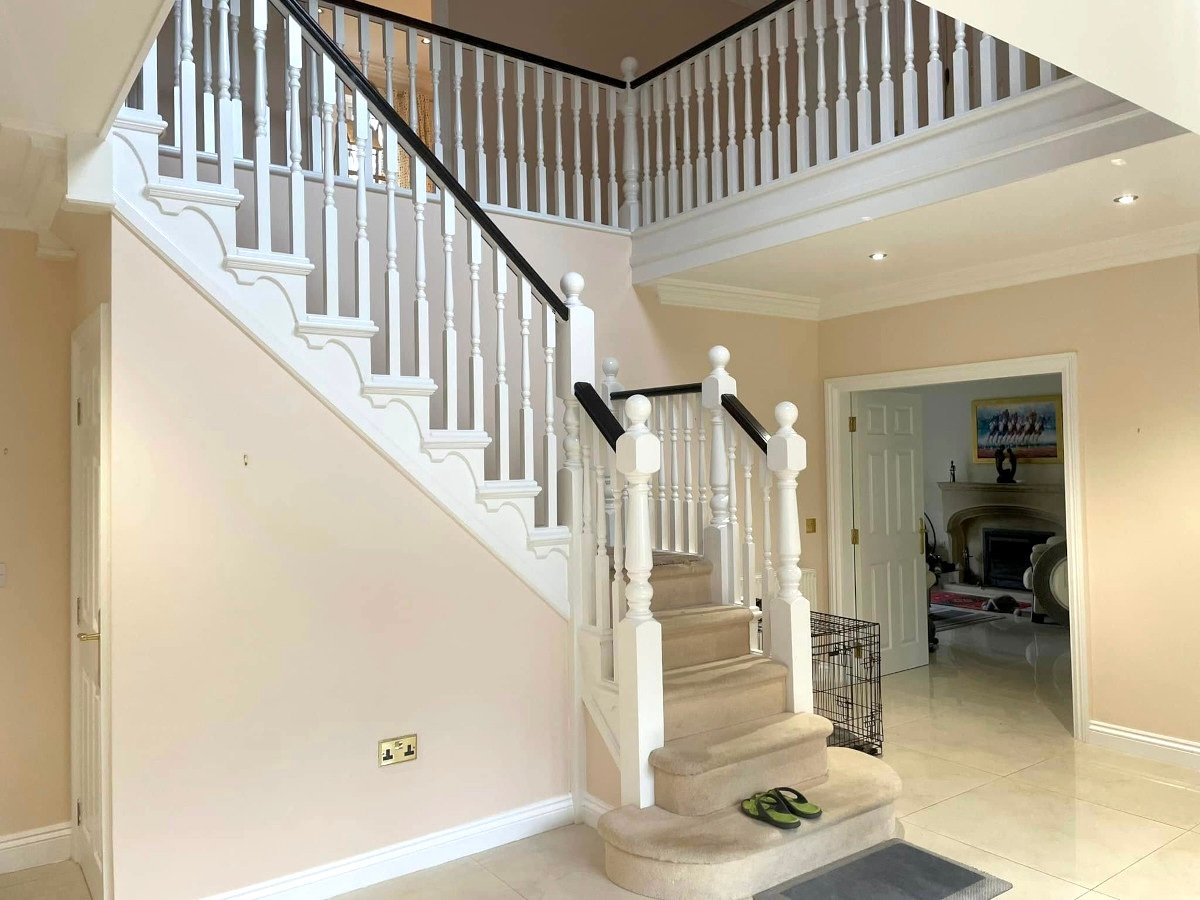 Entryway with cream painted walls and grand staircase in Newport