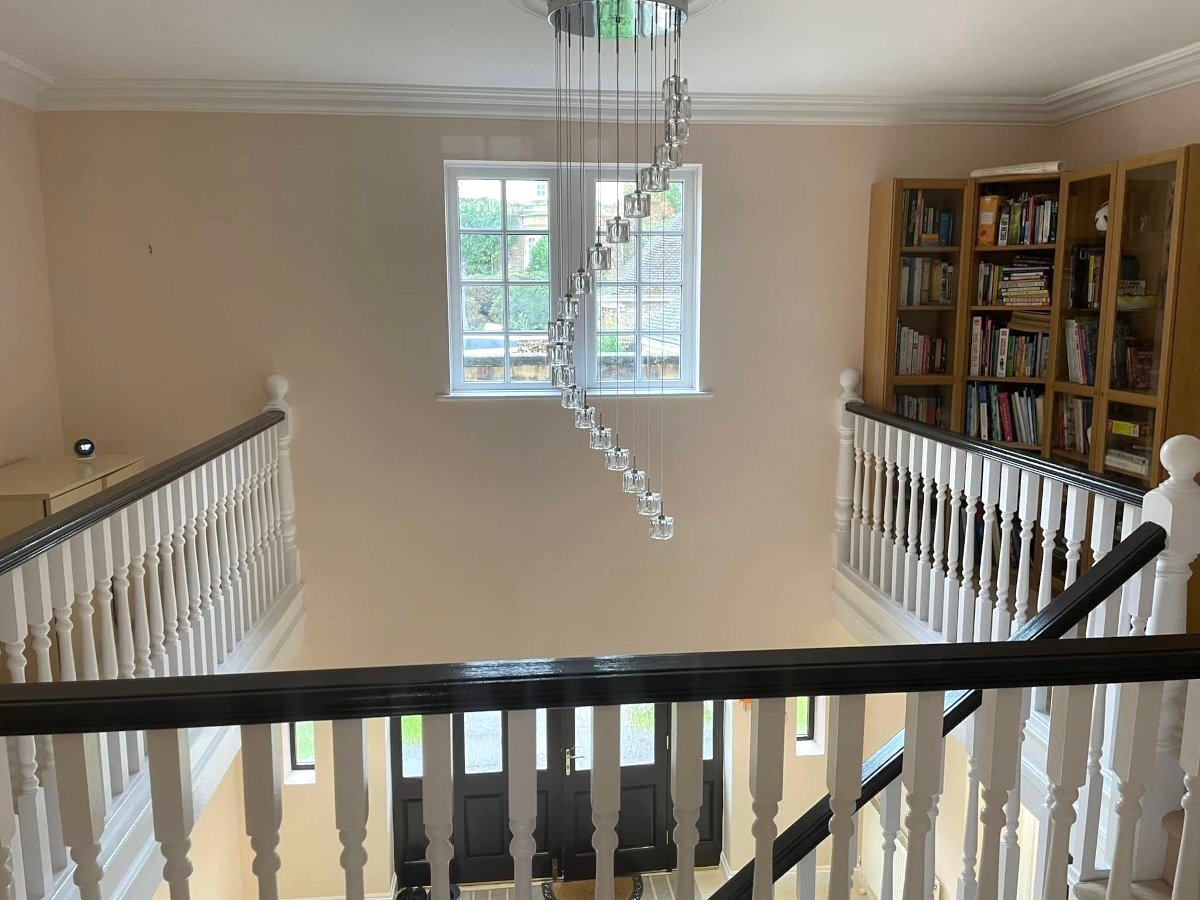 Period landing with beige painted walls, chandelier and bookshelves — interior decorating in Monmouth by Orchid Decor