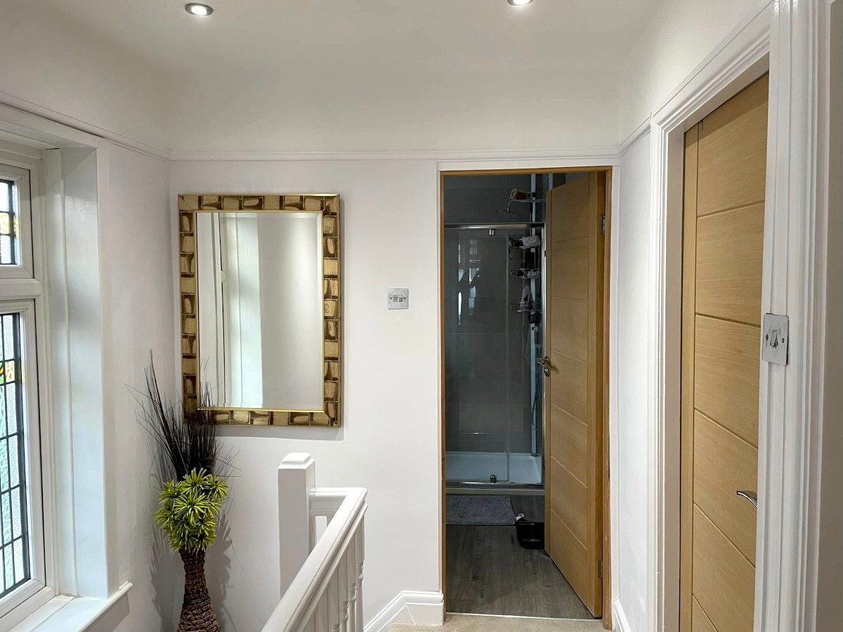 living-room-beige-painted-walls-leather-sofa-chandelier-newport-orchid-decor Living room with beige painted walls and chandelier in Rogerstone Newport home by Orchid Decor