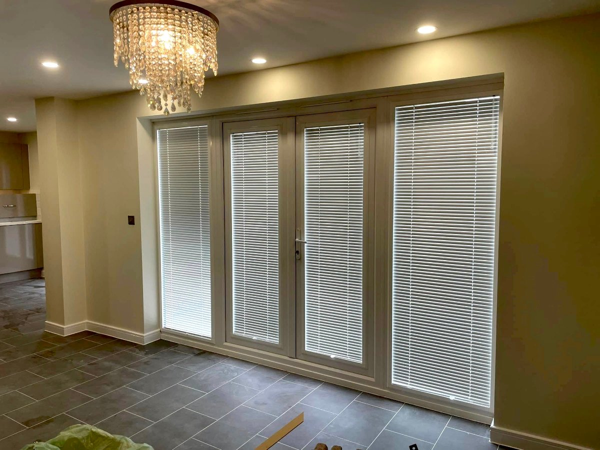 living-room-cream-painted-walls-bifold-doors-chandelier-newport-orchid-decor Living room with cream painted walls, bifold doors, and chandelier in Newport property