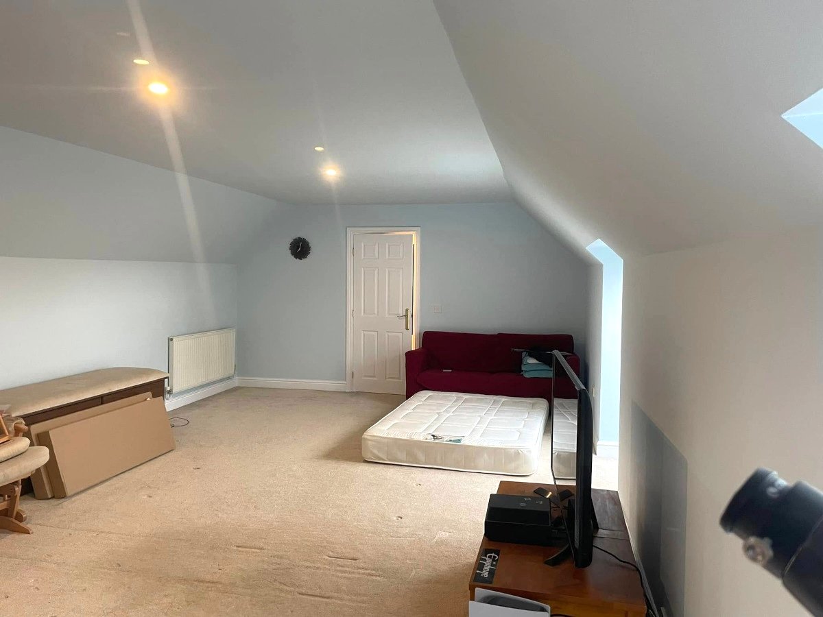 Loft bedroom with aqua painted plasterboard walls and ceiling, Newport