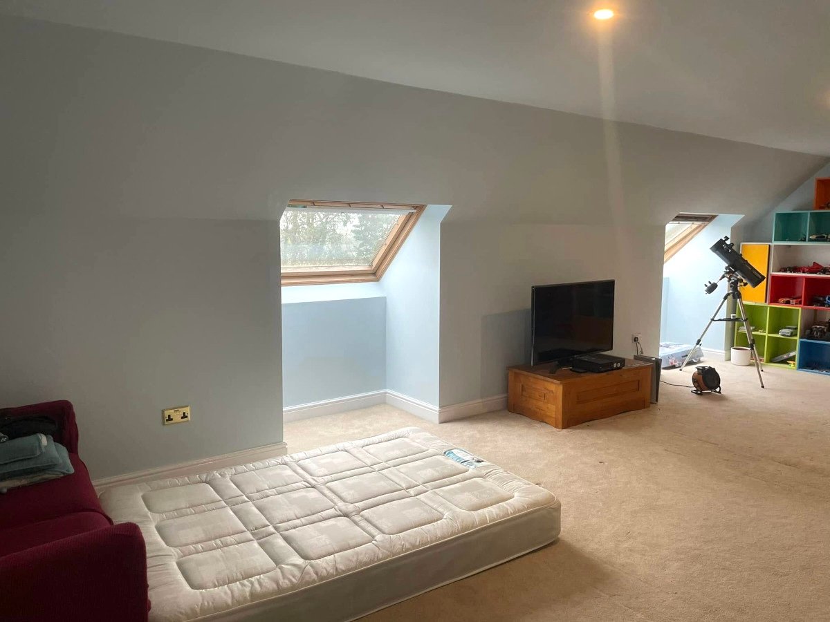 Loft room with grey painted walls and skylights in Newport, suitable as home office